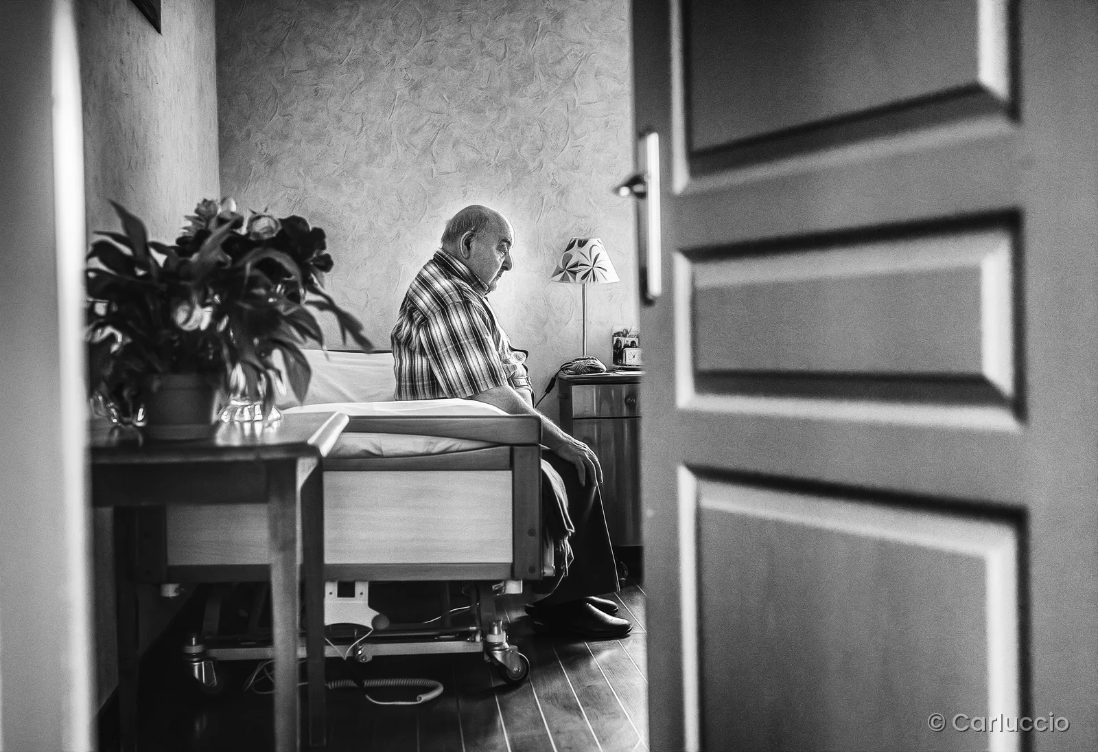 Homme assis dans sa chambre en noir et blanc