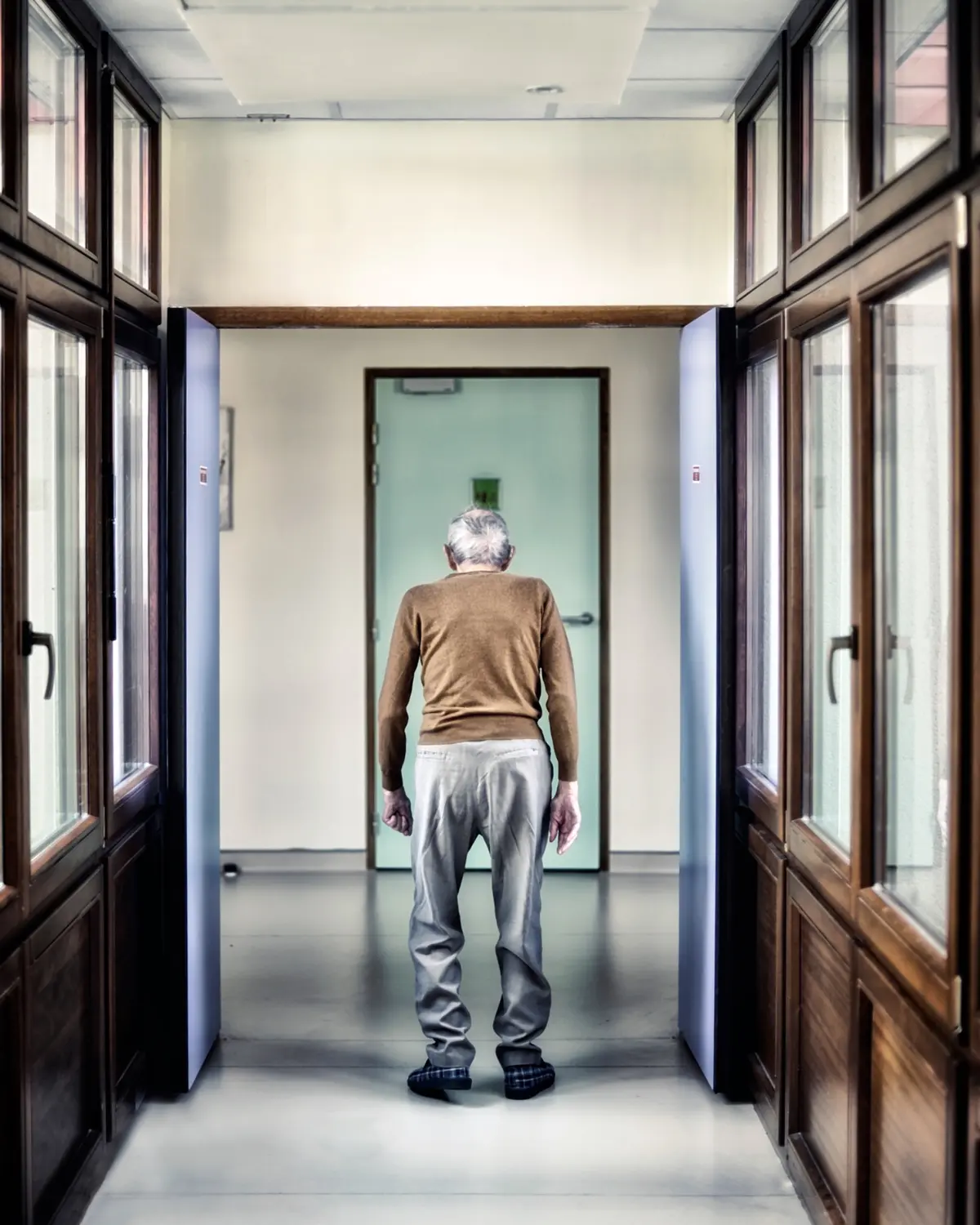 Un homme âgé avançant dans le couloir d’un établissement, photographié par Didier Carluccio