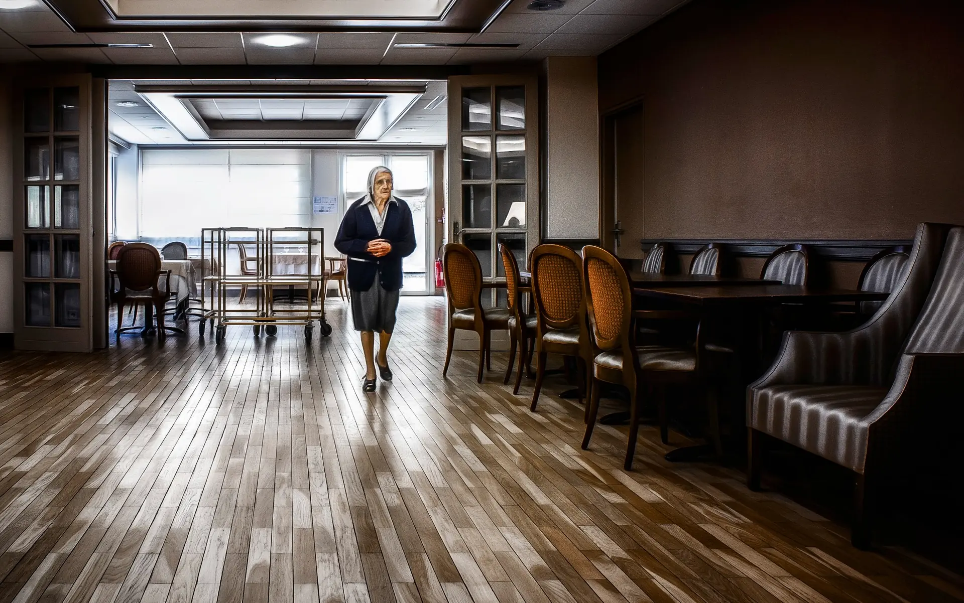 Une femme âgée marchant seule dans une salle, photographiée par Didier Carluccio