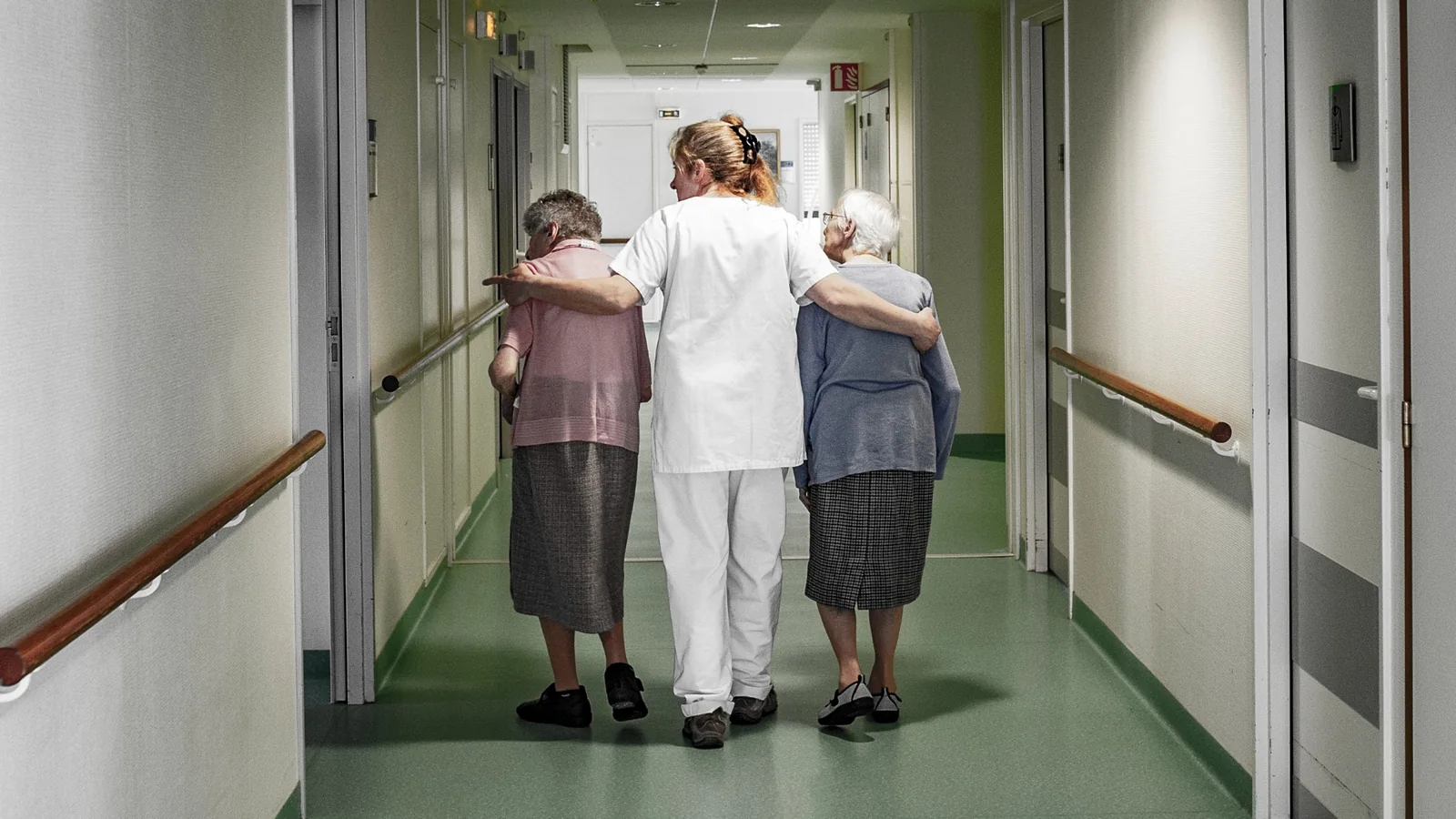 Deux personnes âgées accompagnées dans un couloir, photographie de Didier Carluccio